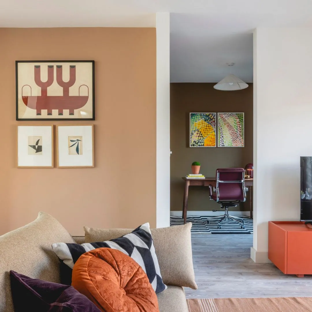 Lounge with bright sofa cushions and orange wall