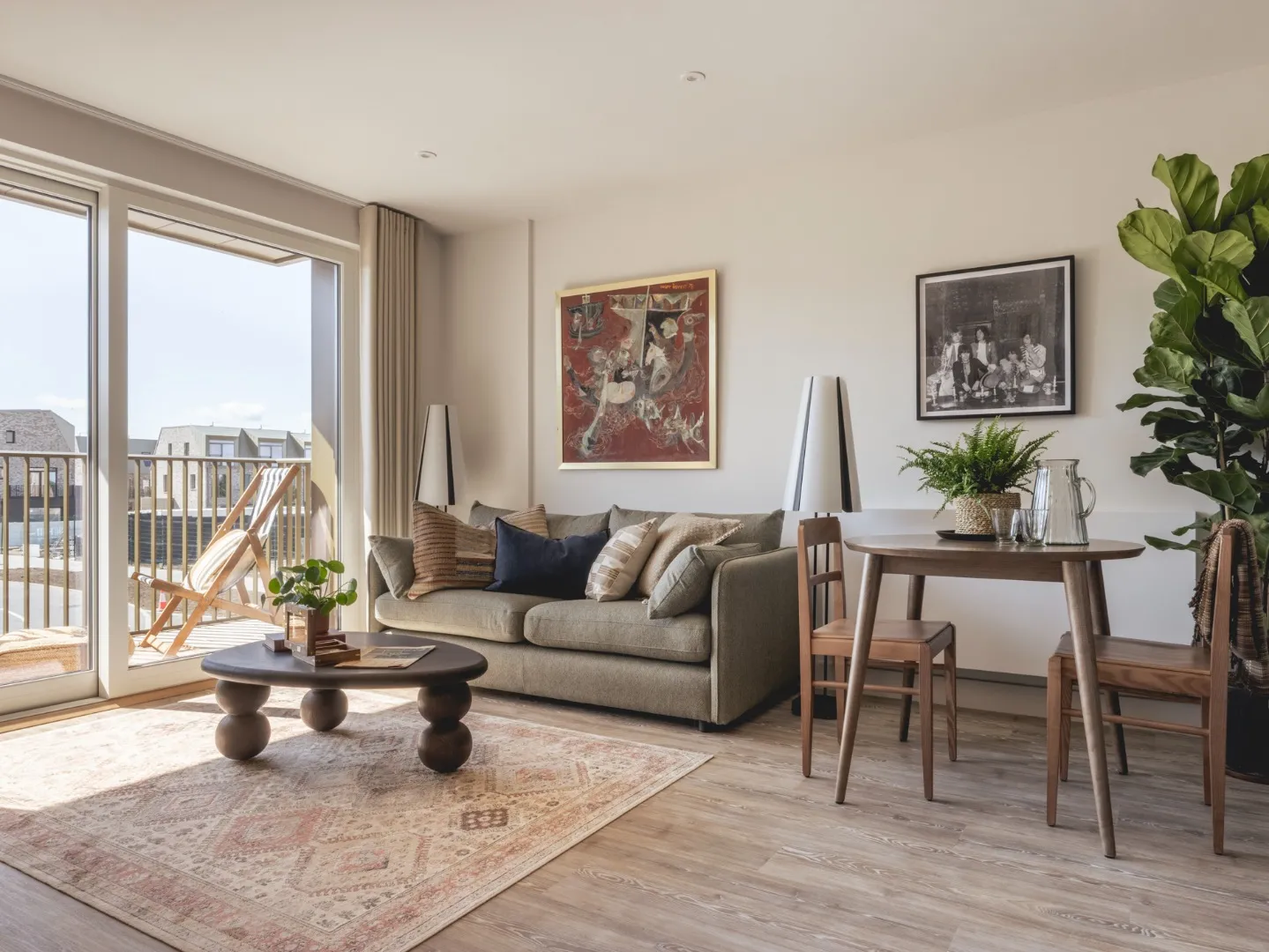 Lounge space with sunlight coming through the window, couch and dining table