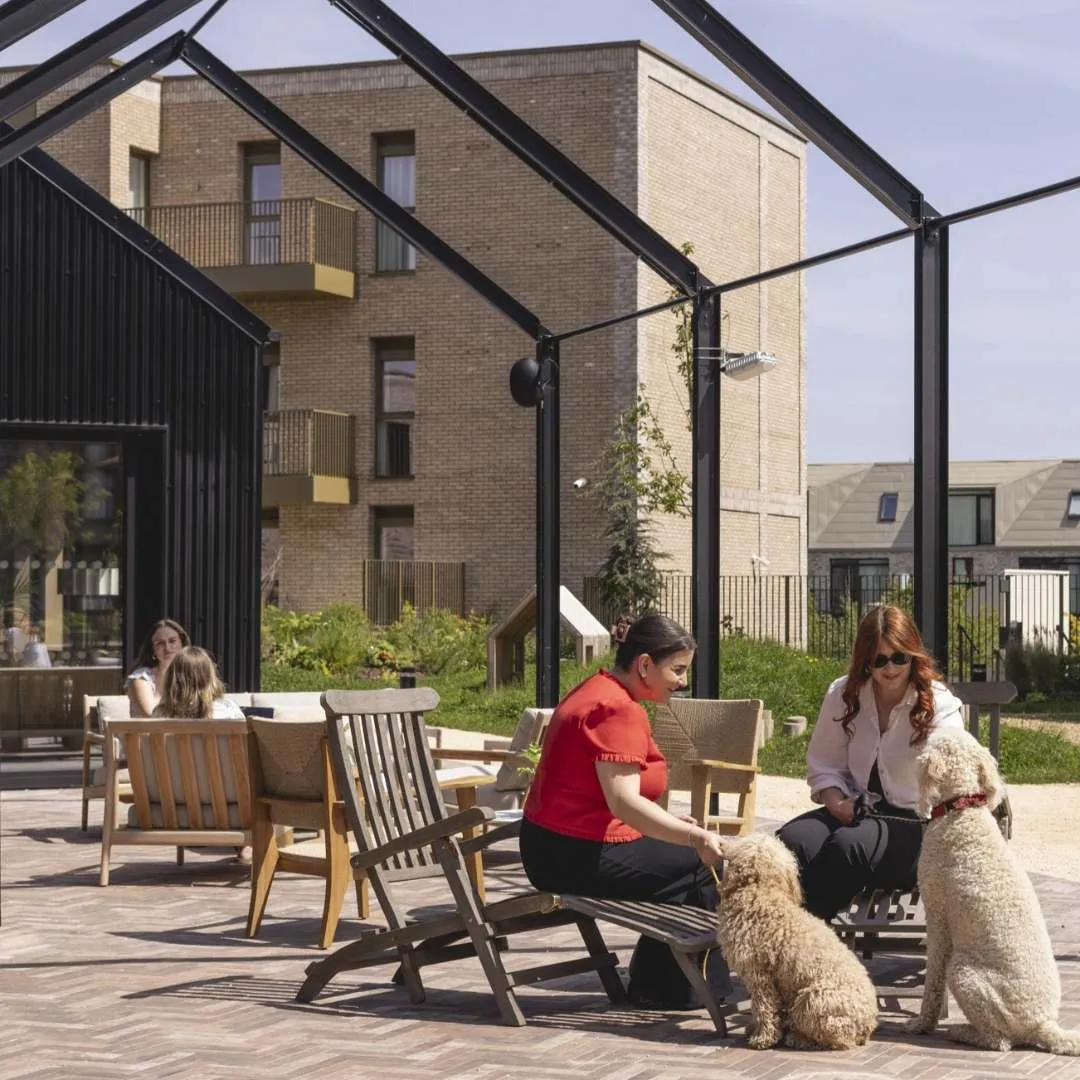Ladies sat in the sun on wooden garden furniture